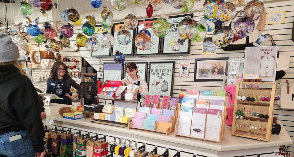 Two clerks working the register of a gift shop
